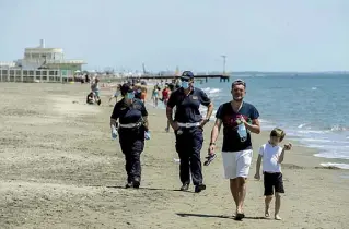  ?? (foto Benvegnù) ?? Due agenti della polizia urbana in servizio antiCovid sull’arenile libero di Ostia