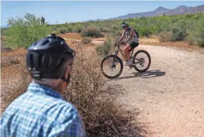  ?? ANTRANIK TAVITIAN/USA TODAY NETWORK ?? Rand Hubbell, left, talks with a fellow mountain biker at McDowell Mountain Regional Park near Fountain Hills, Ariz.