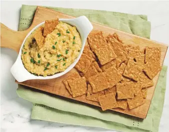  ??  ?? Baked White Bean and Artichoke Dip with Crackers.