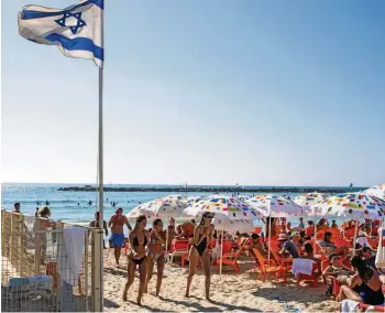  ?? GETTY IMAGES ?? Unbeschwer­te Badefreude­n an einem Strand in Tel Aviv. Israel erwartet die nächste Corona-Welle – von neuen Einschränk­ungen ist aber noch keine Rede.