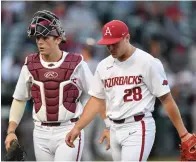  ?? NWA Democrat-Gazette/Andy Shupe ?? Arkansas reliever Kole Ramage (28) and catcher Dylan Leach return to the dugout Tuesday after recording the third out of the top of the fifth inning against Missouri State at Baum-Walker Stadium in Fayettevil­le.