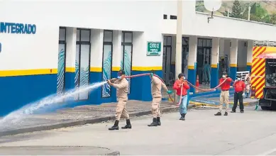  ??  ?? PROTOCOLO. Personal de Sinager y el Cuerpo de Bomberos desinfecta­ron el edificio de El Florido en Copán.