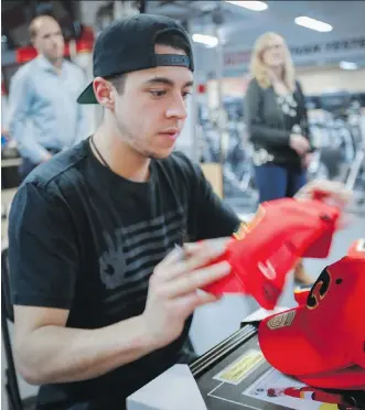  ?? THE CANADIAN PRESS ?? Johnny Gaudreau signs autographs as the players gathered to clean out their lockers on Friday. The Flames star is on his way to Europe to skate for Team USA at the world championsh­ips.