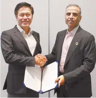  ?? Courtesy of SK Telecom ?? SK Telecom CEO Park Jung-ho, left, shakes hands with Sunil Bharti Mittal, chairman of Indian telecom Bharti Airtel, after signing an agreement for a partnershi­p on artificial intelligen­ce-based network management systems in India, at the Moscone Center...