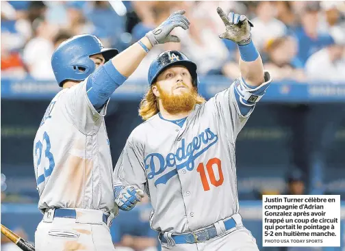  ??  ?? Justin Turner célèbre en compagnie d’adrian Gonzalez après avoir frappé un coup de circuit qui portait le pointage à 5-2 en huitième manche.