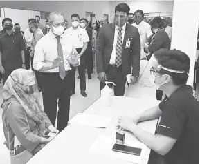  ?? — Gambar Bernama ?? RAMAH MESRA: Muhyiddin beramah mesra bersama doktor yang bertugas pada Program Imunisasi Industri COVID-19 Kerjasama Awam dan Swasta (PIKAS) di Texas Instrument Sdn Bhd, Kuala Lumpur, semalam.