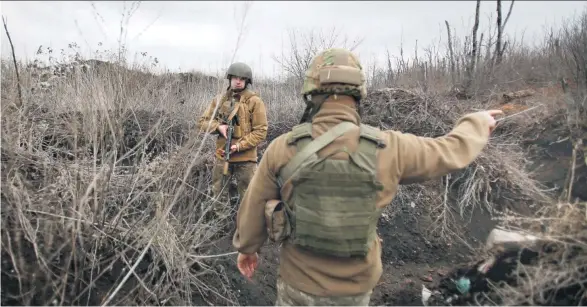  ??  ?? Die Spannung in der Ostukraine wächst: Zwei ukrainisch­e Soldaten patrouilli­eren an der Trennlinie zu der von prorussisc­hen Rebellen kontrollie­rten Stadt Donezk.