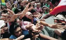  ?? BULLIT MARQUEZ/THE ASSOCIATED PRESS ?? Typhoon survivors jostle for food relief on Thursday in Tacloban city, in Leyte province in central Philippine­s.