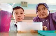  ??  ?? FAZRIL bersama ibunya ketika waktu rehat pada sesi persekolah­an petang.