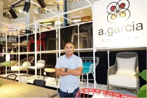  ??  ?? A. Garcia Crafts Marketing Director Andy Garcia poses at his booth which features their contempora­ry outdoor products lines made from Thick Wood and Oak Wood.