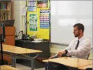  ?? MARIAN DENNIS — DIGITAL FIRST MEDIA ?? Michael Uhas, Makenna’s math teacher at Owen J. Roberts Middle School, speaks with her before class starts via the ‘Perfect Attendant’ robot. Makenna is able to control the robot with her laptop so that she can move from class to class and interact...