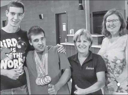  ?? SUBMITTED ?? Jason Hanks, left, congratula­tes Anthony James for capturing five medals, while Heather Patton and Janice Milton join in.