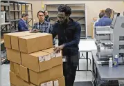  ?? JOE SKIPPER / GETTY IMAGES ?? Elections staff bring boxes of ballots into the tabulation room for machine counting as recounting begins at the Broward County Supervisor of Elections Office on Sunday in Lauderhill, Florida.