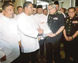  ?? [FOTO DANIAL SAAD/BH] ?? Rafizal menyerahka­n memorandum mendesak SPRM segerakan siasatan terhadap Guan Eng kepada Dzulkifli di pekarangan pintu masuk KOMTAR, Georgetown, semalam.