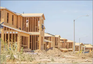  ?? PHOTOS BY BOBBY BLOCK / THE SIGNAL ?? Crews work to finish a row of new houses being built as part of the Skyline Ranch developmen­t project near Plum Canyon Park. While the market supply has been listed as a challenge by Realtors, there are new homes and projects under way across the SCV.