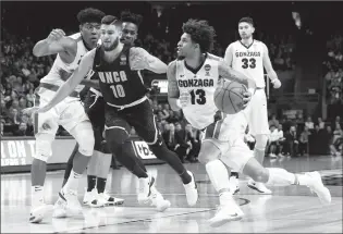  ?? Associated Press photo ?? Gonzaga guard Josh Perkins (13) drives against UNC-Greensboro guard Francis Alonso (10) as Gonzaga forward Rui Hachimura looks on at left, during the second half of an NCAA college basketball tournament first-round game, Thursday, in Boise, Id.