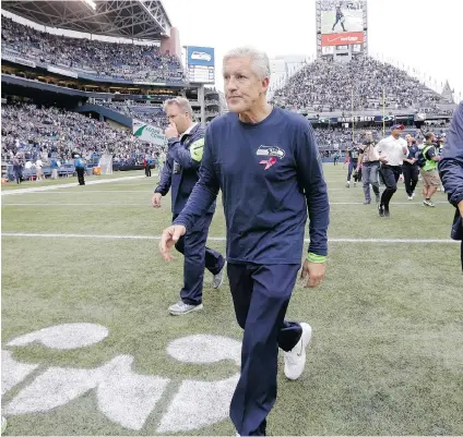  ?? ELAINE THOMPSON/ THE ASSOCIATED PRESS ?? Pete Carroll walks off the fi eld after Seattle’s 30- 23 loss to the Dallas Cowboys on Sunday. Carroll has a lot to manage. He must work with off ensive co- ordinator Darrell Bevell to rein in the off ence without making it too vanilla.