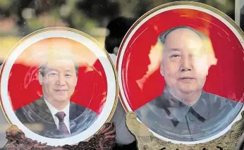 ?? S portréty Si Ťin-pchinga (vlevo) a Mao Ce-tunga ve výloze pekingskéh­o obchodu FOTO REUTERS ?? Upomínkové talíře