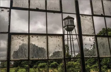  ?? PHOTOS BY BRYAN DENTON, NEW YORK TIMES ?? An American-built water tower in Fordlândia, Brazil, is among the rusting remains in the Amazon town, where Henry Ford tried turning a colossal swath of Brazilian jungle into a Midwest fantasylan­d. It stands as a crumbling testament to the folly of...