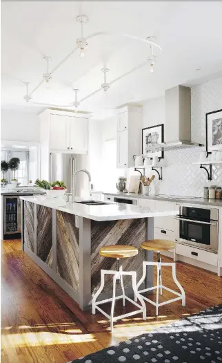  ?? STACEY BRANDFORD ?? Using an island or a table in the kitchen depends on the family’s day-to-day requiremen­ts. This island design by Sarah Richardson Design suits a larger kitchen.