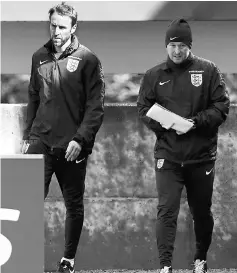  ??  ?? England manager Gareth Southgate (left) and first team coach Steve Holland arrive for training at St George’s Park. — Reuters photo