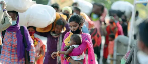  ??  ?? In viaggio
Una donna tiene in braccio un bambino in mezzo a un folla di altri migranti, pronti a tonare a casa, nello stato di Jammu in India. Dal 4 maggio l’india ha allentato il lockdown (Ap)