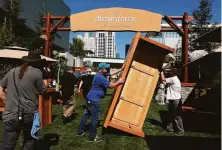  ?? Lea Suzuki / The Chronicle ?? Daniel Barron (left) and Chris McGinnis, trade show installers for Freeman Co., move a counter into place for Dreamforce.