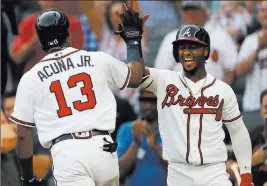  ?? John Bazemore ?? The Associated Press Ronald Acuna Jr. celebrates with Braves teammate Ozzie Albies after hitting his second leadoff home run Monday in Atlanta’s doublehead­er sweep of the Marlins.