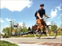  ?? DAVID BEBEE, RECORD STAFF ?? A cyclist riding the Spur Line Trail crosses Union Street in Waterloo Wednesday. The city is exploring ways to make the crossing safer.