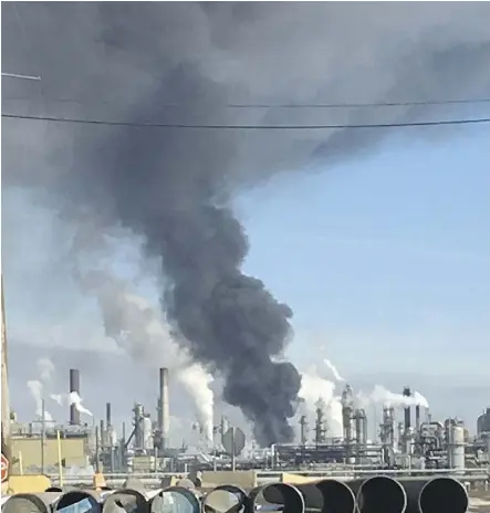  ??  ?? A plume of smoke hangs over Syncrude Canada Ltd.’s Mildred Lake Upgrader near Fort McMurray on Tuesday. One worker said the fire, which has been brought under control, occurred in the plant’s hydrotreat­ing unit.