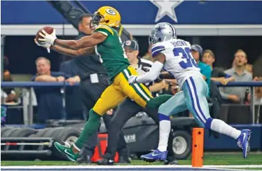  ?? THE ASSOCIATED PRESS PHOTOS ?? Green Bay’s Davante Adams hauls in a touchdown pass in front of Dallas cornerback Anthony Brown during the first half of Sunday’s game in Arlington, Texas. Adams finished with 66 yards on seven catches, including two touchdowns, to help lead the...