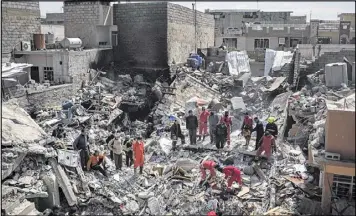  ?? FELIPE DANA / ASSOCIATED PRESS ?? Civil protection rescue teams search a week later through the debris of a building destroyed in a March 17 U.S. airstrike in the western sector of Mosul. The strike killed more than 100 civilians who were taking refuge from fighting.