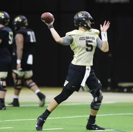  ?? Cliff Grassmick, Daily Camera ?? CU quarterbac­k JT Shrout winds up to throw a pass during the Buffs’ first spring football practice on Wednesday in Boulder.