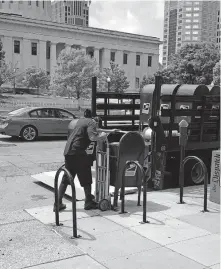  ?? [BETHANY BRUNER VIA USA TODAY] ?? A Postal worker removes mailboxes May 29 in downtown Columbus, Ohio. He said they were being removed because of damage in the area after protests the night before. The boxes were returned Aug. 21.