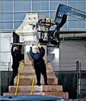  ?? GERALD HERBERT/AP ?? Workers in New Orleans dismantle the Liberty Place monument, which paid tribute to white supremacis­ts who tried to topple a biracial post-Civil War government.