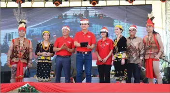  ??  ?? Baru (fourth left) presses a tab to declare open the Christmas Carnival at Lawas while others look on.