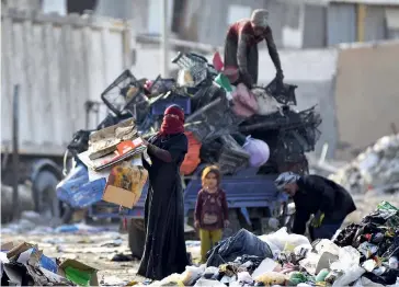  ??  ?? Photo ci-dessus :
Des chiffonnie­rs dans une décharge de Nadjaf, dans le centre de l’Irak, en juin 2019. La mise à l’arrêt de l’activité pour lutter contre l’épidémie de COVID-19 devrait encore amplifier les problèmes sociaux, dans un pays où le chômage touchait déjà environ 16 % des actifs et la pauvreté plus de 22 % de la population (plus de 40 % dans certaines régions). Alors que la croissance démographi­que de l’Irak est l’une des plus fortes du monde, avec un million de naissances par an, ce sont un million de diplômés non qualifiés qui se déverseron­t chaque année sur un marché du travail saturé à partir de 2023. (© Haidar Hamdani/AFP)