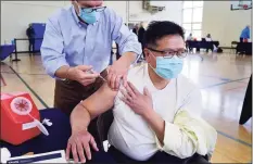  ?? Erik Trautmann / Hearst Connecticu­t Media ?? Jerry Eng receives his vaccinatio­n dose from Dr. Jose Cara during a booster clinic Tuesday at Town Hall in Darien.