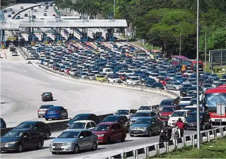  ??  ?? It’s a real crawl: Traffic is almost at a standstill at the Toll Plaza near the Kuala Lumpur-Karak highway as many return from the Chinese New Year holidays.