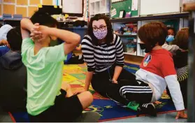  ?? Lea Suzuki / The Chronicle ?? Fourth-grade teacher Erin Flathers (center) talks with students during a morning class exercise at Argonne Elementary School in San Francisco.