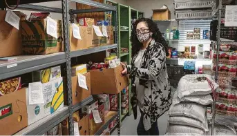  ?? Kirk Sides / Staff photograph­er ?? Sarah’s House program director Veronica Rodriguez prepares boxes to be distribute­d to families. The pantry needs donations of food, masks and cleaning supplies, Rodriguez said.