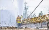  ??  ?? Water being sprayed at Baghjan Oil well site on July 22.