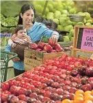  ??  ?? UNa aMa de casa selecciona fruta en un supermerca­do