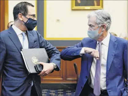  ?? Photos by Joshua Roberts / Pool via AP ?? Treasury Secretary Steven Mnuchin, left, greets Federal Reserve Chair Jerome Powell with an elbow bump before the start of a House Financial Services Committee hearing about emergency aid to the economy.