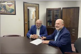  ?? CLEVELAND BALLET/HARBOURTOW­N FINE ARTS COUNCIL ?? Harbourtow­n Fine Arts Center President Jim Chapple, right, and Michael Krasnyanks­y, president and CEO of Cleveland Ballet, sign their agreement for the Cleveland-based dance company to have its summer residency in Vermilion in August and September 2022 at the opera house of Vermilion’s 1883 Town Hall building.