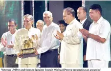  ?? PIC BY KUSHAN PATHIRAJA ?? Veteran UNPER and former Speaker Joseph Michael Perera presenting an award of felicitati­on to Premier Ranil Wickremesi­nghe who had been a member of the J. R. Jayewarden­e’s Cabinet which introduced the market economy in 1977.