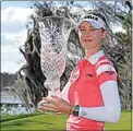  ?? STAN BADZ / AP ?? Nelly Korda celebrates with the winner’s trophy Sunday after the final round of the Gainbridge LPGA in Orlando, Fla.