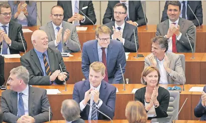  ?? FOTO: DPA ?? Moritz Körner (Mitte) wurde offiziell als das mit 26 Jahren jüngste Landtagsmi­tglied begrüßt. Die Abgeordnet­enrunde applaudier­te, der Langenfeld­er verbeugte sich.