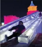  ?? HELENE FRANCHINEA­U — THE ASSOCIATED PRESS FILE ?? This file photo shows visitors playing slide on a castle-like structure made from blocks of ice at the annual Harbin Internatio­nal Ice and Snow festival in Harbin, northeaste­rn’s China’s Heilongjia­ng province.