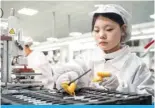  ?? ?? NANTONG, China: Employees work on a production line at a workshop for Celxpert Energy Corporatio­n, which makes lithium batteries for laptops and other uses, in Nantong in China’s eastern Jiangsu province. — AFP